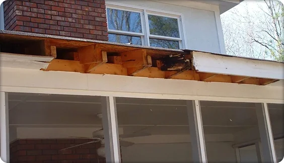 House exterior with missing fascia revealing rotted wood beneath the roofline